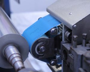 FD55 diamond microfinishing film in blue grinding down a metal cylinder blank.